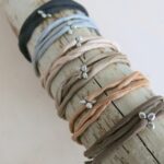 Seidenarmband mit versilbertem Blümchen-Anhänger